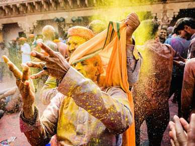 A man dressed in a yellow and brown traditional outfit participates in the colorful Holi Festival 2020 in Vrindavan, Uttar Pradesh, India