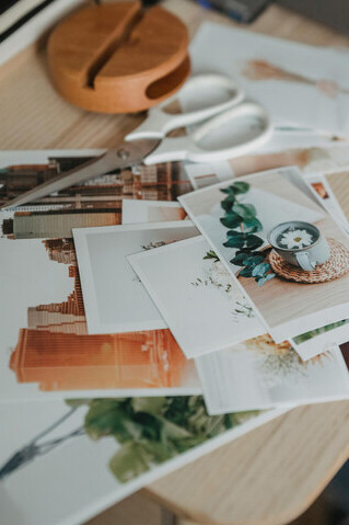 Autora monta mesa repleta de fotos, tesoura e recortes de revista para inspirar um moodboard