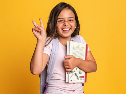 Criança feliz após adquirir livro que tano queria