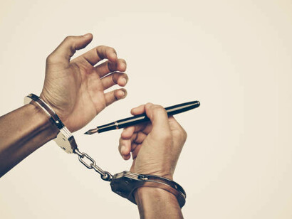 Handcuffed hands symbolize censorship, reflecting the suppression of freedom of the press and the broader struggle for liberty and free expression