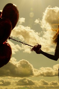 A woman holding a bunch of red heart-shaped balloons