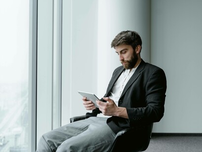 A man scanning his tablet for ways to manipulate the system toward his interest 