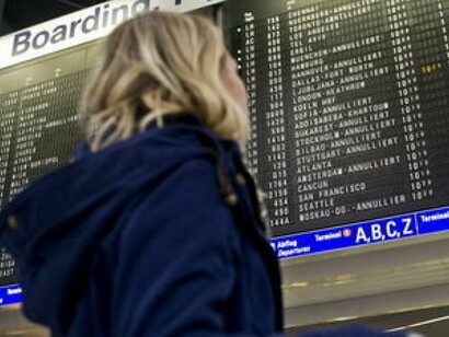 Young woman looking at the information screens in an airport