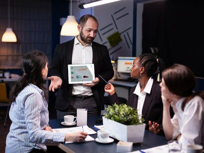 A leader discussing visual insights during a team meeting, conveying how understanding emerges through shared conversation