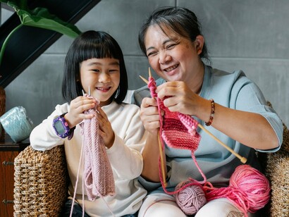 A grandmother passing on craft lessons through gentle instruction, symbolising how traditions remain alive when they are practiced, not merely displayed