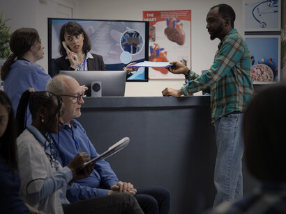 A busy hospital lobby waiting room with a reception desk, where diverse patients sit and wait for their checkup or emergency care