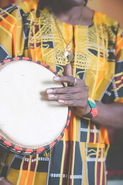 Adorned in traditional African garments, a skilled musician passionately engages with an instrument, weaving a rich tapestry of cultural rhythms and melodies