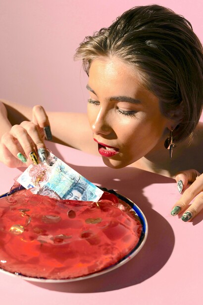 Mulher puxando dinheiro de uma gelatina