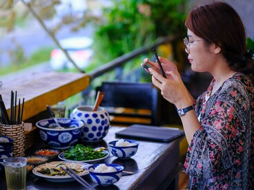 A traveler photographing a freshly served local meal, representing the growing appeal of food-focused travel experiences