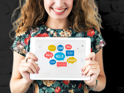 Donna con tablet che riporta scritte in diverse lingue