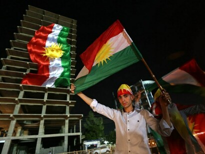 Un joven kurdo con una bandera de su país en una calle de Erbil