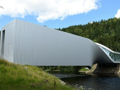 The Twist is a unique combination of a gallery, a bridge, and a sculpture. This 1,000-square-meter structure gracefully twists into a sculptural form, spanning 60 meters across the Randselva River in Norway