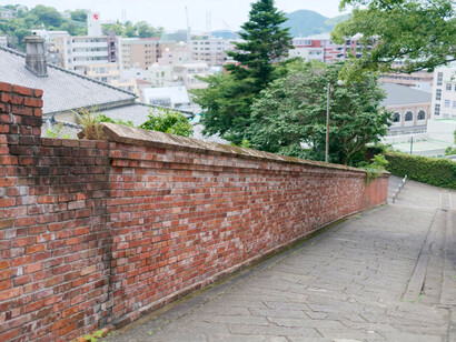 The historic stone-paved Dutch Slope bordered by red brick walls, representing Nagasaki's international heritage