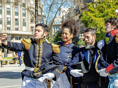 Reencenadores históricos fazem uma selfie em Buenos Aires, transformando uma representação do passado em registro compartilhável no presente. A imagem evoca a política argentina recente, na qual as redes sociais ajudaram a projetar Milei como alternativa ao sistema tradicional. A comunicação digital ampliou o alcance de sua mensagem e contribuiu para uma campanha em que a disputa por atenção e a construção de imagens públicas tiveram papel central