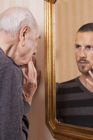 An older man looking at his younger self