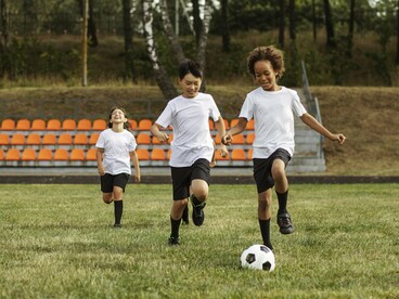 Young players chasing the ball with enthusiasm, symbolising the joy and freedom at the heart of youth sport