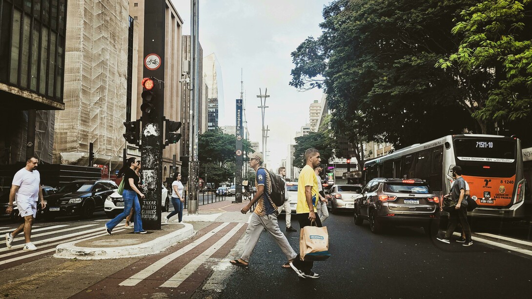 À medida que a dependência do automóvel particular deixa de estruturar os deslocamentos diários, o próprio tecido urbano começa a se transformar. As ruas deixam de ser meros corredores de circulação e passam a assumir funções múltiplas. Faixas exclusivas para ônibus e sistemas BRT organizam o transporte coletivo de alta capacidade. Ciclovias contínuas e seguras conectam bairros e centralidades urbanas. Percursos destinados a patinetes e pequenos veículos elétricos ampliam as possibilidades de deslocamentos de curta distância. Árvores, jardins lineares e espaços de permanência retomam áreas antes dominadas pelo asfalto, enquanto calçadas amplas e sombreadas voltam a convidar as pessoas a caminhar
