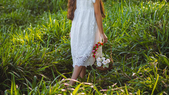 Menina passeia pelo campo para colher flores