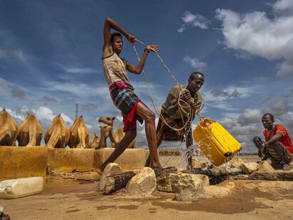 Men drawing water from a well in Somalia captured by Lynsey Addario