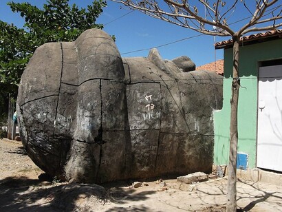 Vista de outro ângulo, a cabeça de Santo Antônio revela as marcas do tempo e as divisões da estrutura de concreto. O monumento inacabado, que por anos permaneceu no meio da cidade, ganhou uma nova dimensão quando sua história chegou à literatura de Socorro Acioli