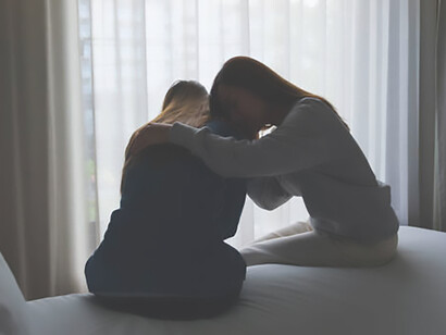 In a tender moment, a woman finds solace in her sister's comforting embrace after a nightmare