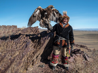 Native American man standing while holding eagle