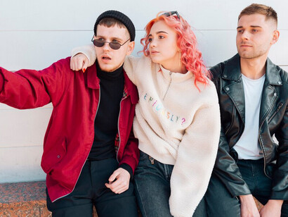 Young friends smiling and exchanging glances, capturing the essence of millennial friendships and their shared moments of joy