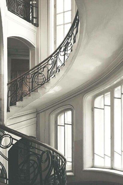 Scala in stile liberty di un palazzo dagli interni bianchi