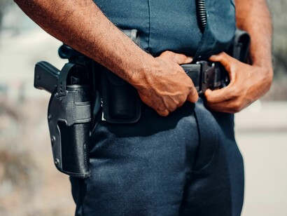 Detalhe do uniforme e equipamentos de um policial em serviço. A presença constante das forças de segurança tornou-se símbolo da crise política abordada no texto