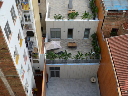 Vista desde la azotea de la calle Roger de Flor, Barcelona, en el barrio de Camp d'en Grassot i Gràcia Nova, mostrando una serie de terrazas en la azotea del edificio de atrás, Barcelona, España