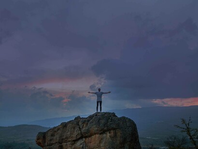 Arms stretched out in the picturesque setting while seizing life