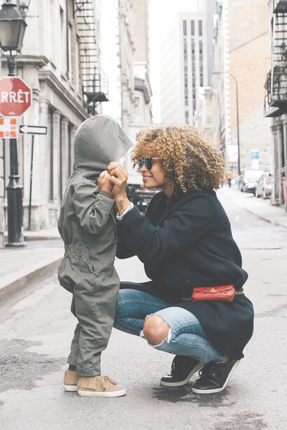 A compassionate woman tenderly holding her child on the bustling street