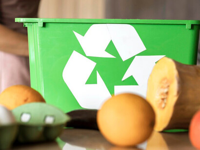 A person sorting organic vegetable waste into a recycling basket to support eco-friendly composting practices
