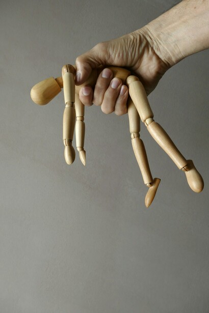 A marionette controlled by a powerful hand 