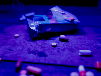 Drugs, syringes, and pills scattered on a table, representing addiction and substance abuse