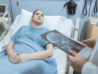On the hospital bed, a woman, gripped by illness, weeps, her vulnerability and pain etched across her face