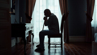 Elderly man sits alone in his room, pondering life's unanswered questions