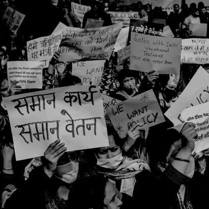 A black-and-white photograph of women protesting with banners, reflecting activism, advocacy, and collective action