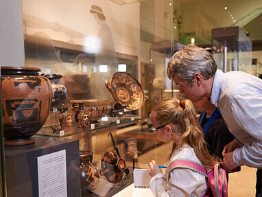 A family on a museum trip studies artifacts displayed in glass, encouraging curiosity, creativity, and emotional connection through art education