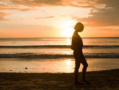Donna che cammina sulla spiaggia: “Camminare sulla sabbia, con le sue piccole instabilità, aiuta a rafforzare i muscoli del piede e della caviglia, mentre l’aria marina ricca di iodio contribuisce a migliorare la respirazione”