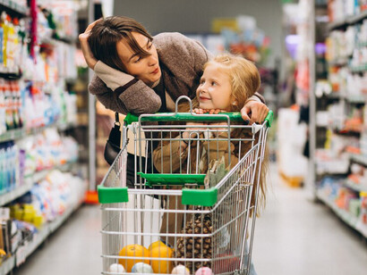 A mother and daughter enjoy shopping together at the grocery store