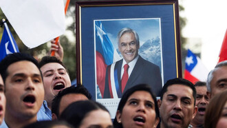 Ciudadanos chilenos sostienen un cuadro del presidente Sebastián Piñera, en honor a su memoria