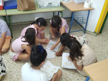 Los niños estudian en el suelo para refrescarse   de las altas temperaturas en las aulas. Colegio público en Huelva, España