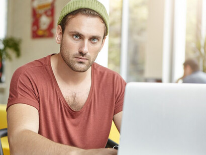 Man in coffee shop using laptop