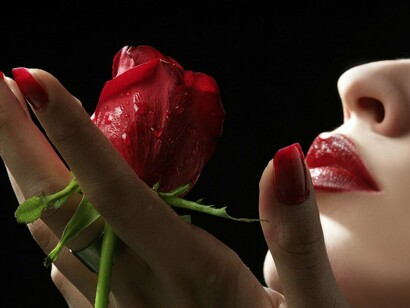Una mujer oliendo una rosa