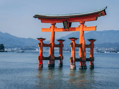 A captivating view of Hiroshima's Itsukushima Shrine at low tide, with the picturesque 1-1 Miyajimacho in Hatsukaichi, Japan, offering a glimpse of Japan’s rich history and stunning natural scenery