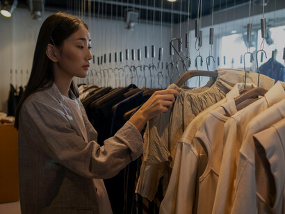 A woman shopping for clothes in a modern, minimalist luxury store