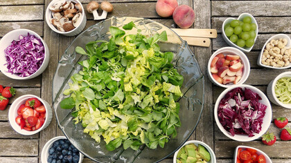 Piattini e ciotole con insalata e frutta