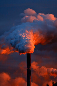 This stark image of factories emitting thick plumes of smoke illustrates the environmental challenges posed by industrialisation, highlighting the urgent need for sustainable practices