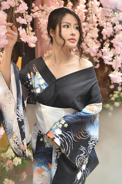 A woman in a kimono surrounded by cherry blossoms in japan